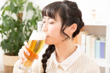 Arka planda bira içen Asyalı kadın