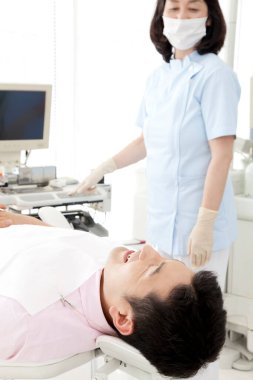 Klinikteki Asyalı dişçi ve hasta 