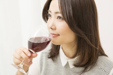 Güzel Japon kadın evde şarap içiyor.