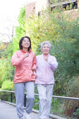 Parkta koşan iki Asyalı kadın..