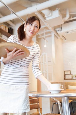 Ahşap tepside kahve servisi yapan genç Japon garson.