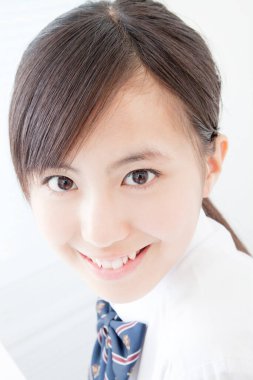 Okul üniformalı genç Japon kızın stüdyo portresi.