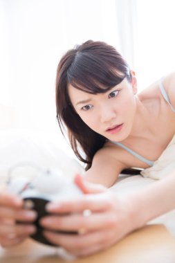 çalar saat yatakta olan kadın