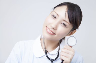 Steteskoplu genç Asyalı kadın doktor, stüdyo fotoğrafı.