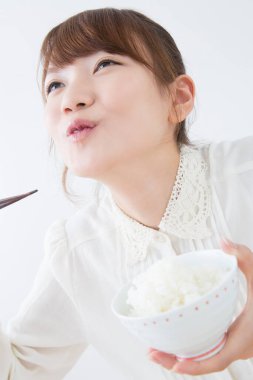 Pirinç yiyen genç bir kadın.