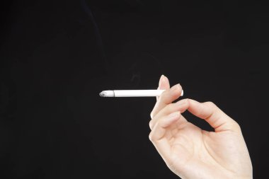 Kadın arka planda sigara içiyor.