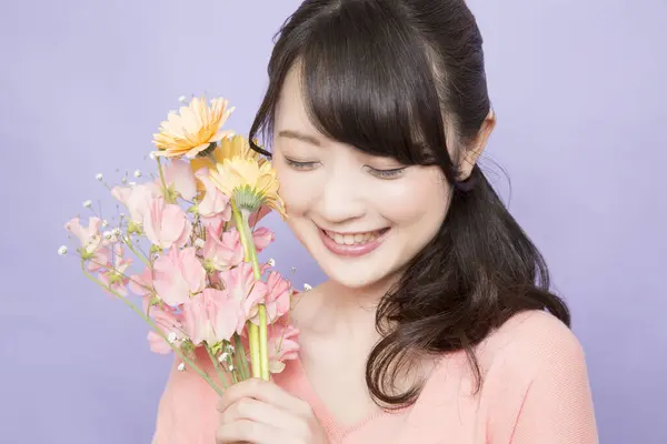 笑顔の若いアジアの女性は花束を保持しています — ストック写真