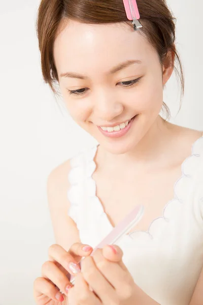 漂亮的亚洲女人在家修指甲 — 图库照片