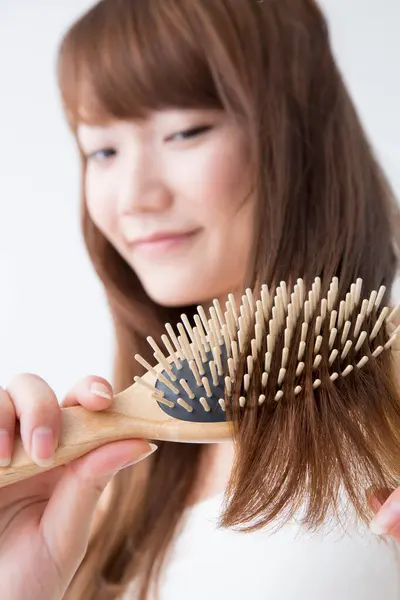 woman with long hair brushing hair