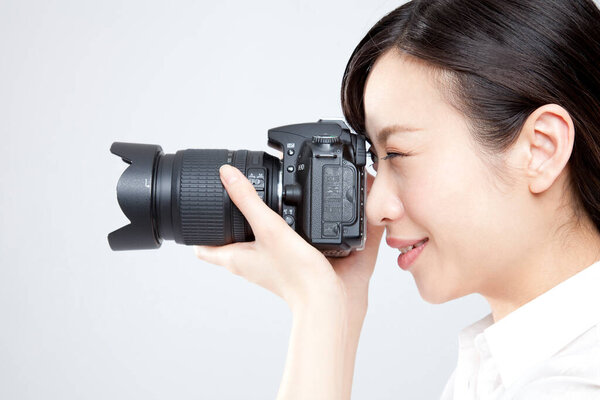 woman holding photo camera, studio shot
