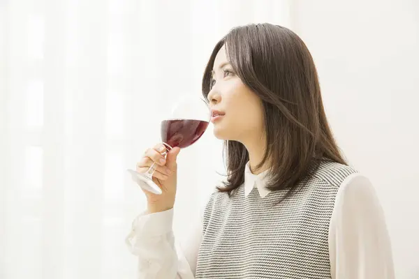 beautiful Japanese woman drinking wine at home