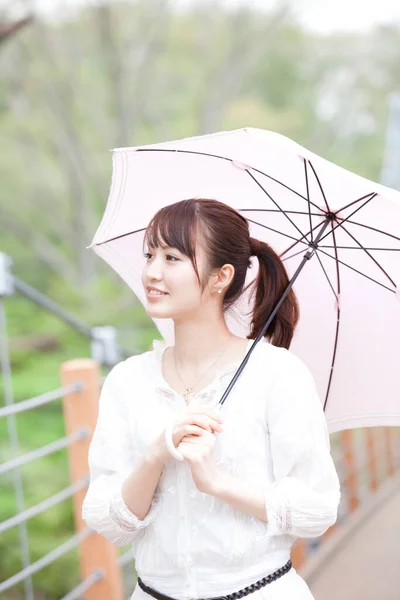 young asian woman with umbrella in park