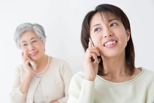 Asian Senior Woman Young Woman Talking Mobile Phones — Stock Photo, Image