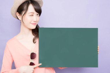 Boş yeşil bayrağı olan gülümseyen Asyalı genç kadın.