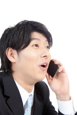 Genç Asyalı işadamı cep telefonundan konuşuyor.