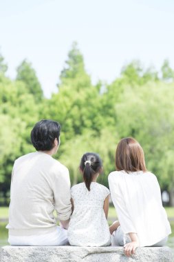 Parkta oturan çocuklu aile.