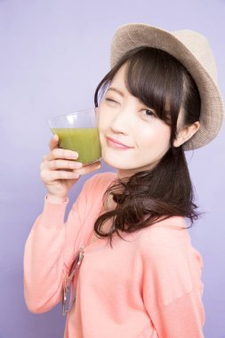 Elinde yeşil kibrit çayı tutan kadın.