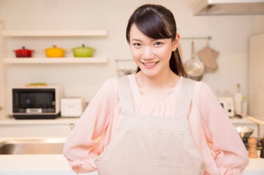 Mutfakta duran önlük giymiş güzel Japon kadın.