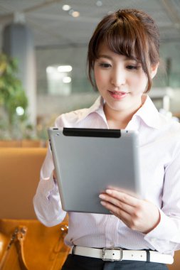 Kafede dijital tablet kullanan genç bir kadın