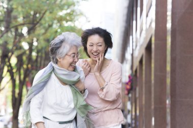 Sokakta yürüyen iki Asyalı kadın.