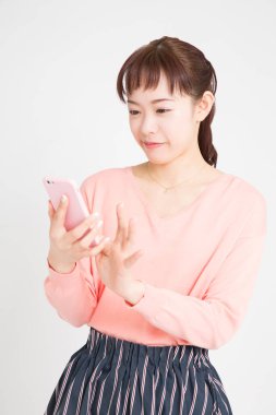 Beyaz arka planda cep telefonu kullanan Asyalı kadın 