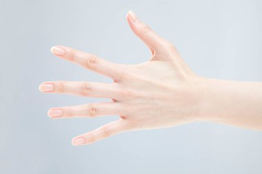 Beyaz arka planda el hareketi yapan kadınların yakın çekimi. 