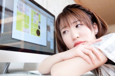 Bilgisayarın başında oturan Asyalı kadın.