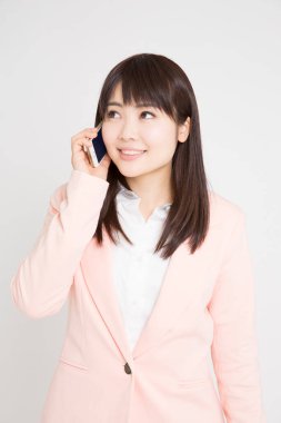 Beyaz arka planda akıllı telefon kullanan Asyalı kadın. 