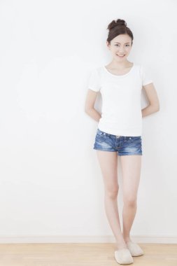 Beyaz tişörtlü kadın beyaz arka planda poz veriyor. 