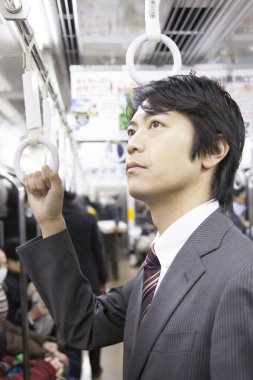 Yetişkin Japon iş adamının portresi metroda çalışacak.