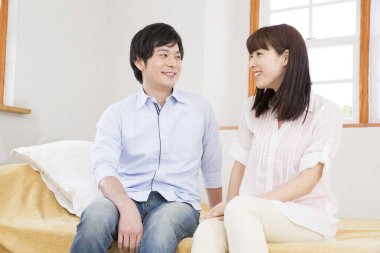 Genç çift oturma odasında oturuyor.