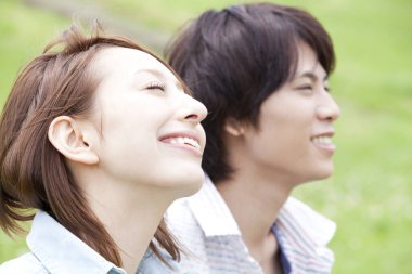 Aşık Asyalı genç çift dışarıda dinleniyor.