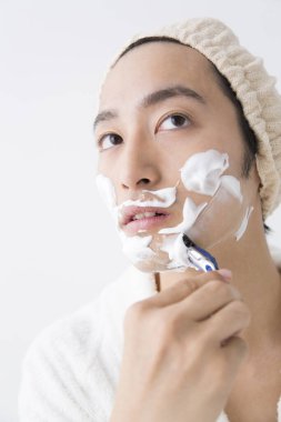 Sakallı ve tıraş köpüğü olan genç bir Japon.