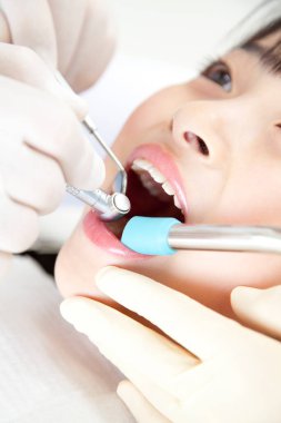 Dişleri muayene eden genç bir dişçi.