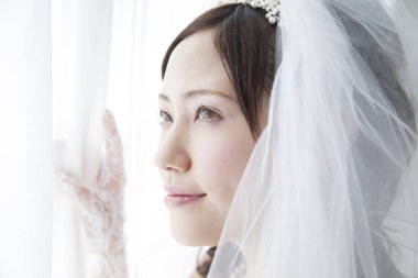 Pencere kenarında duvağı olan güzel Japon gelini.