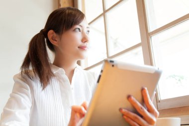 Kafede tablet bilgisayar kullanan iş kadını 