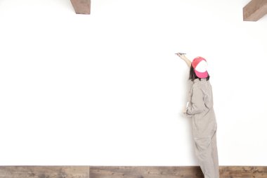 Modern restoranda duvarları dekaralize eden genç bayan işçi.