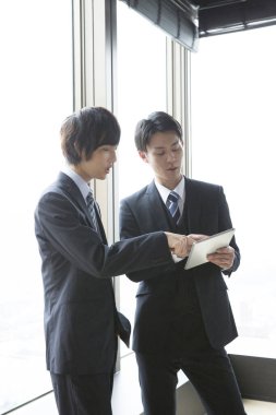 Ofiste birlikte çalışan iki genç Asyalı iş adamının portresi.