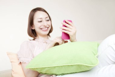 Stüdyoda akıllı telefonu olan genç bir kadın.