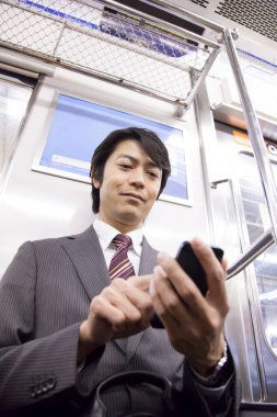 Yetişkin Japon iş adamının portresi metroda çalışacak.