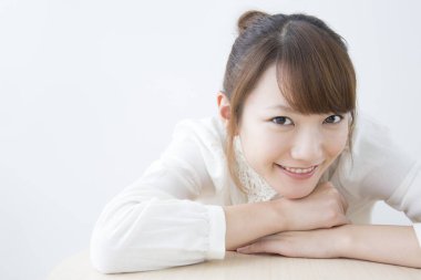 Beyaz arka planda gülümseyen Asyalı kadın.