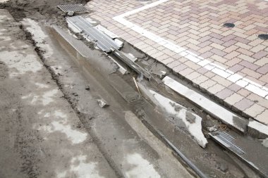Yıkılmış beton ve döküntüleri açığa çıkaran kaldırım taşları zarar görmüş.
