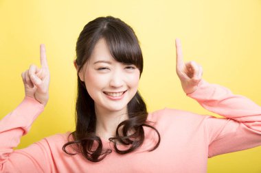 Sarı arka planda pembe elbiseli Japon kadın. 