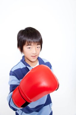 Asyalı çocuk kırmızı boks eldiveni giyiyor. 