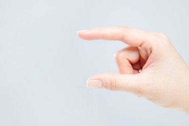 Beyaz arka planda el hareketi yapan kadınların yakın çekimi. 