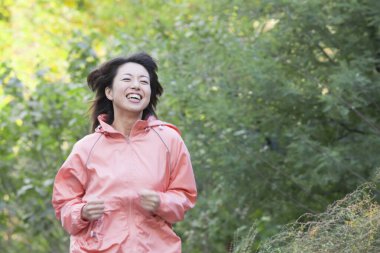 Ormanda koşan Asyalı kadın.