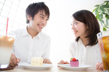 Bir adam ve bir kadın tatlı masasında oturuyor.