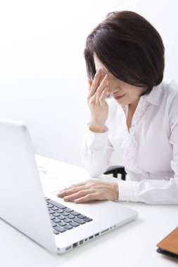 Ofiste dizüstü bilgisayarla çalışan Asyalı kadın.