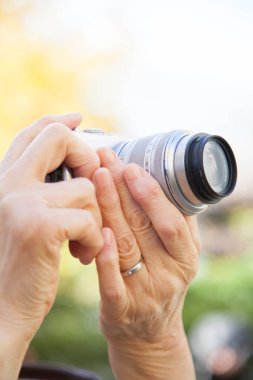 Kapalı - son sınıf öğrencisi bir kadının dışarıda fotoğraf makinesi tutarken.