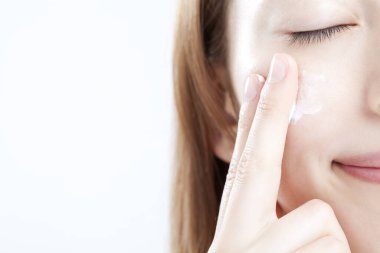 Makyaj yapan güzel genç bir kadın, beyaz arka planda yakın plan portresi